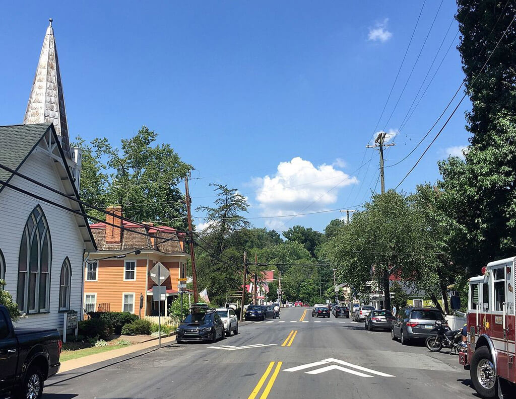 Street view of Clifton, VA with cars parked on the road and church on the left