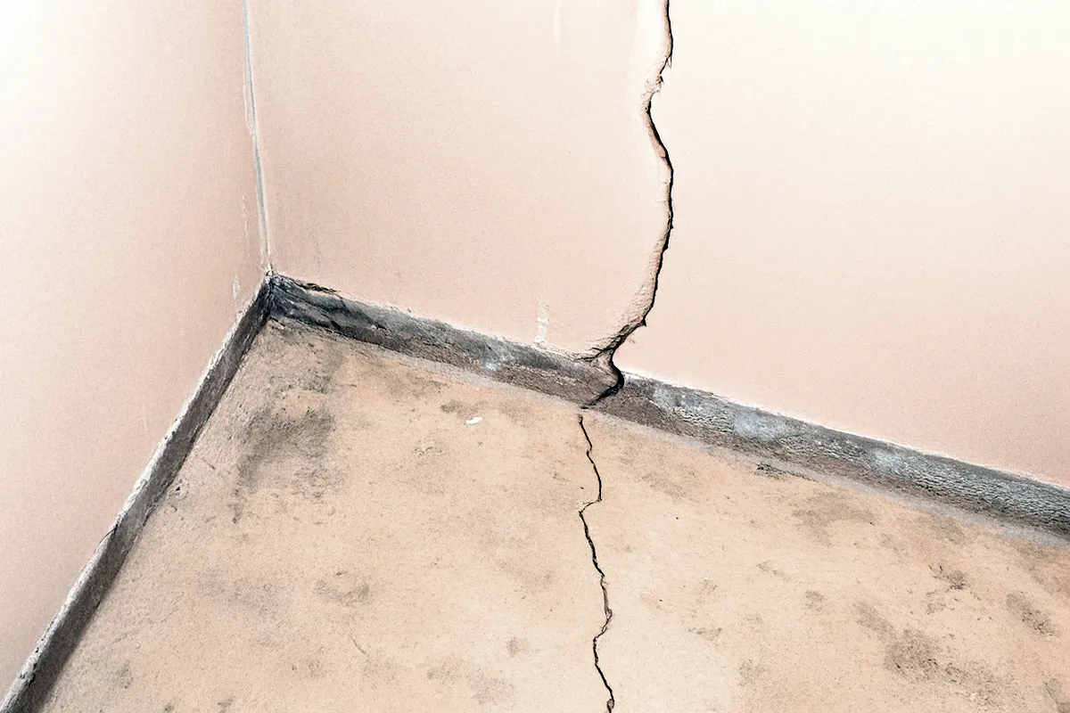 Cracks in a bowing wall and foundation, and cracks on the concrete floor.